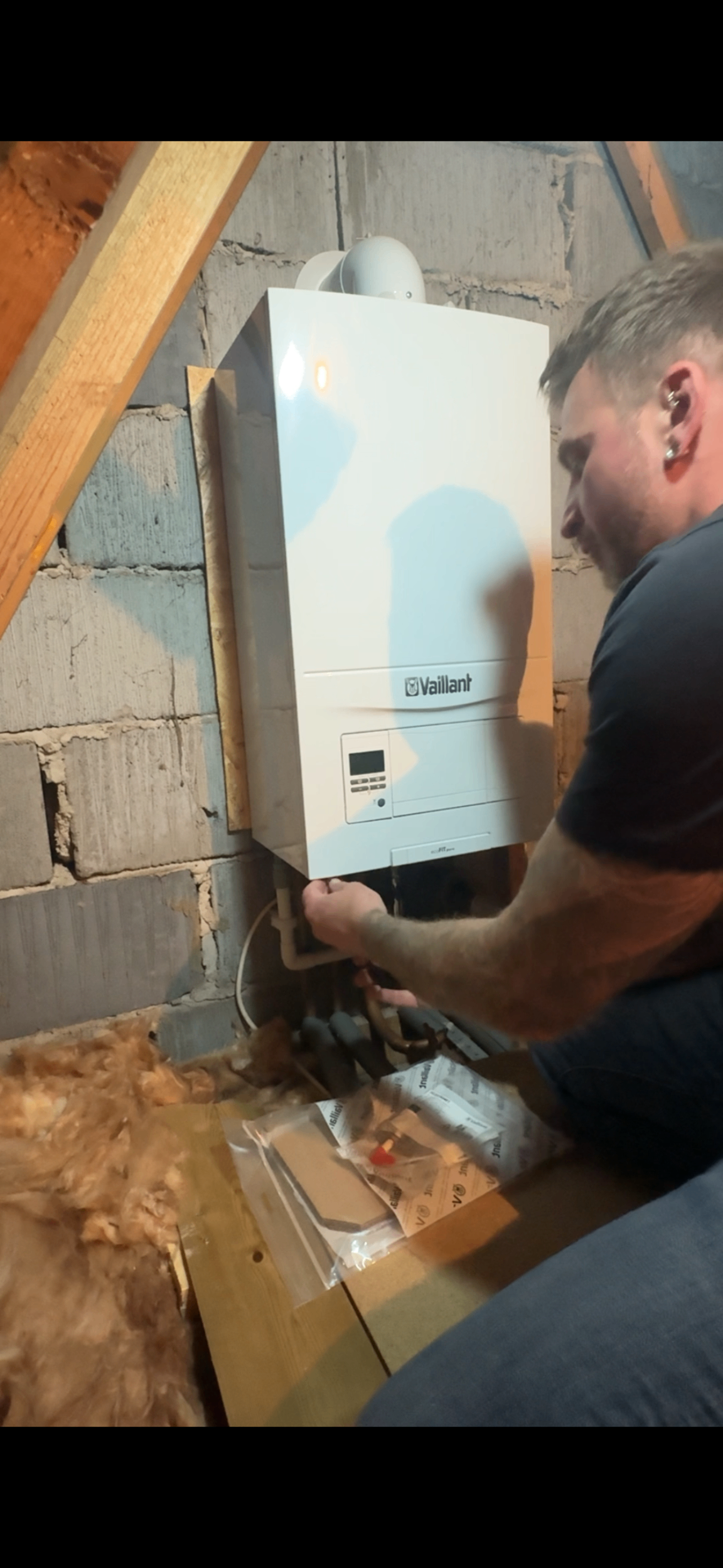 Engineer servicing a Vaillant ecoFIT pure boiler in a loft installation